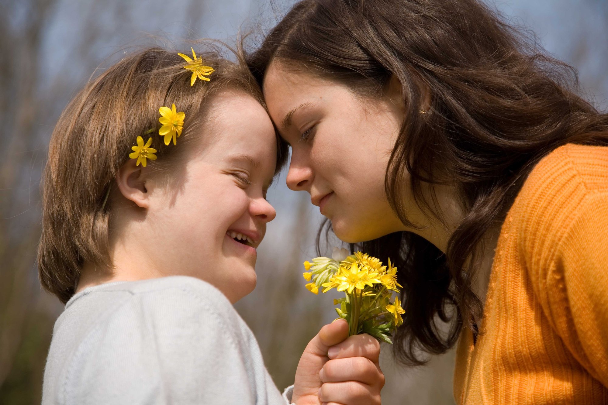young-woman-with-yellow-flowers-and-sister-head-to-head